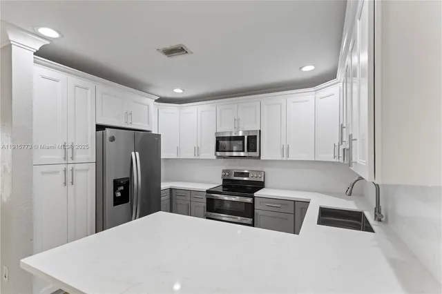 a kitchen with stainless steel appliances a refrigerator stove microwave and sink