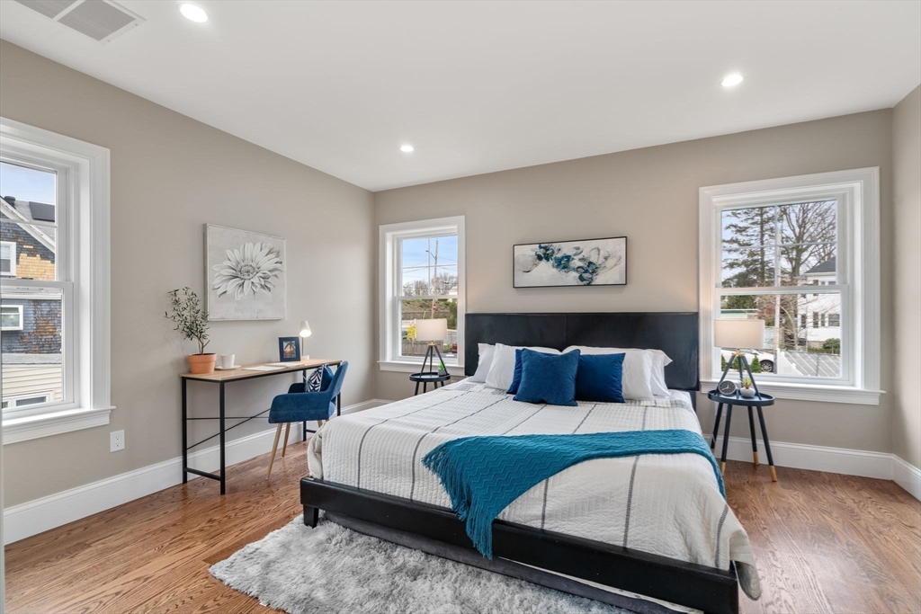 79 Read Street Winthrop, MA 02152 - Photo 26 of 33 a bedroom with a large bed a workstation with paintings on the wall and a large window