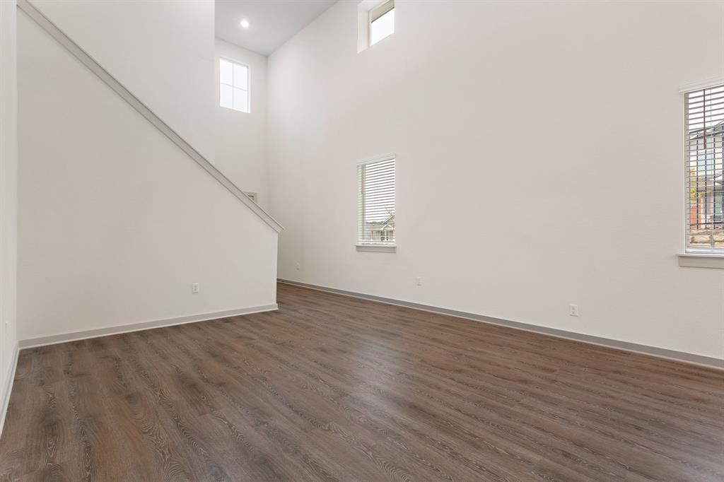 101 Merrick Road Georgetown, TX 78628 - Photo 14 of 38 Photo example of unfurnished living room with plenty of natural light, a high ceiling, and dark wood-type flooring