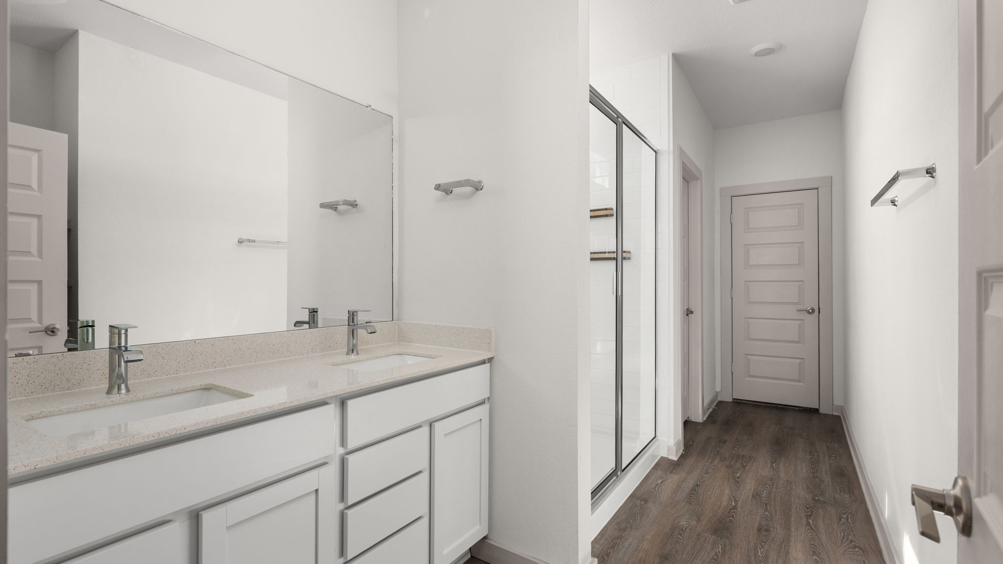 101 Merrick Road Georgetown, TX 78628 - Photo 21 of 38 Primary bathroom with double vanity, a stall shower, and wood-style flooring