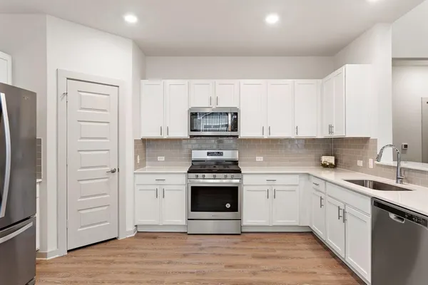 a kitchen with stainless steel appliances granite countertop a stove and a refrigerator