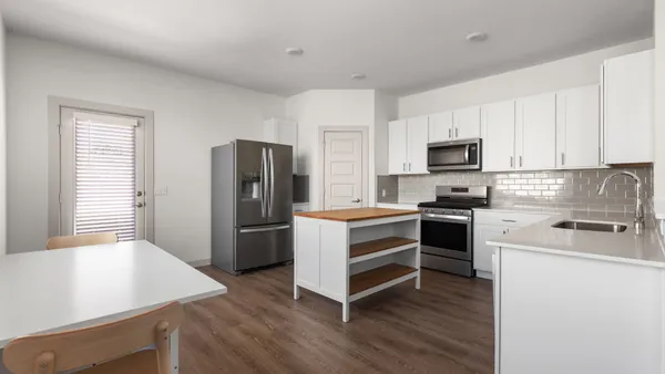 a kitchen with a refrigerator stove and wooden cabinets