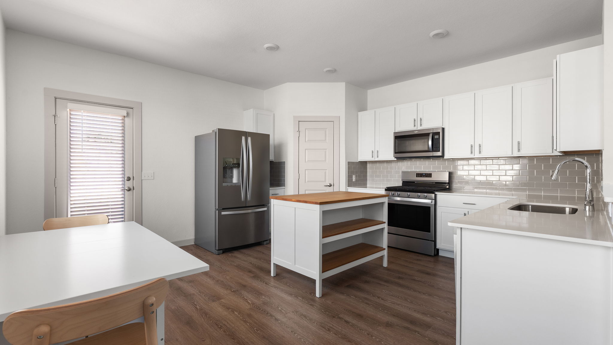 101 Merrick Road Georgetown, TX 78628 - Photo 8 of 38 Optional Kitchen island & dining table available. Kitchen featuring stainless steel appliances, white cabinets, open shelves, and decorative backsplash