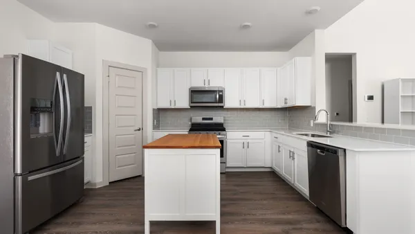 a kitchen with stainless steel appliances granite countertop a refrigerator stove top oven and sink