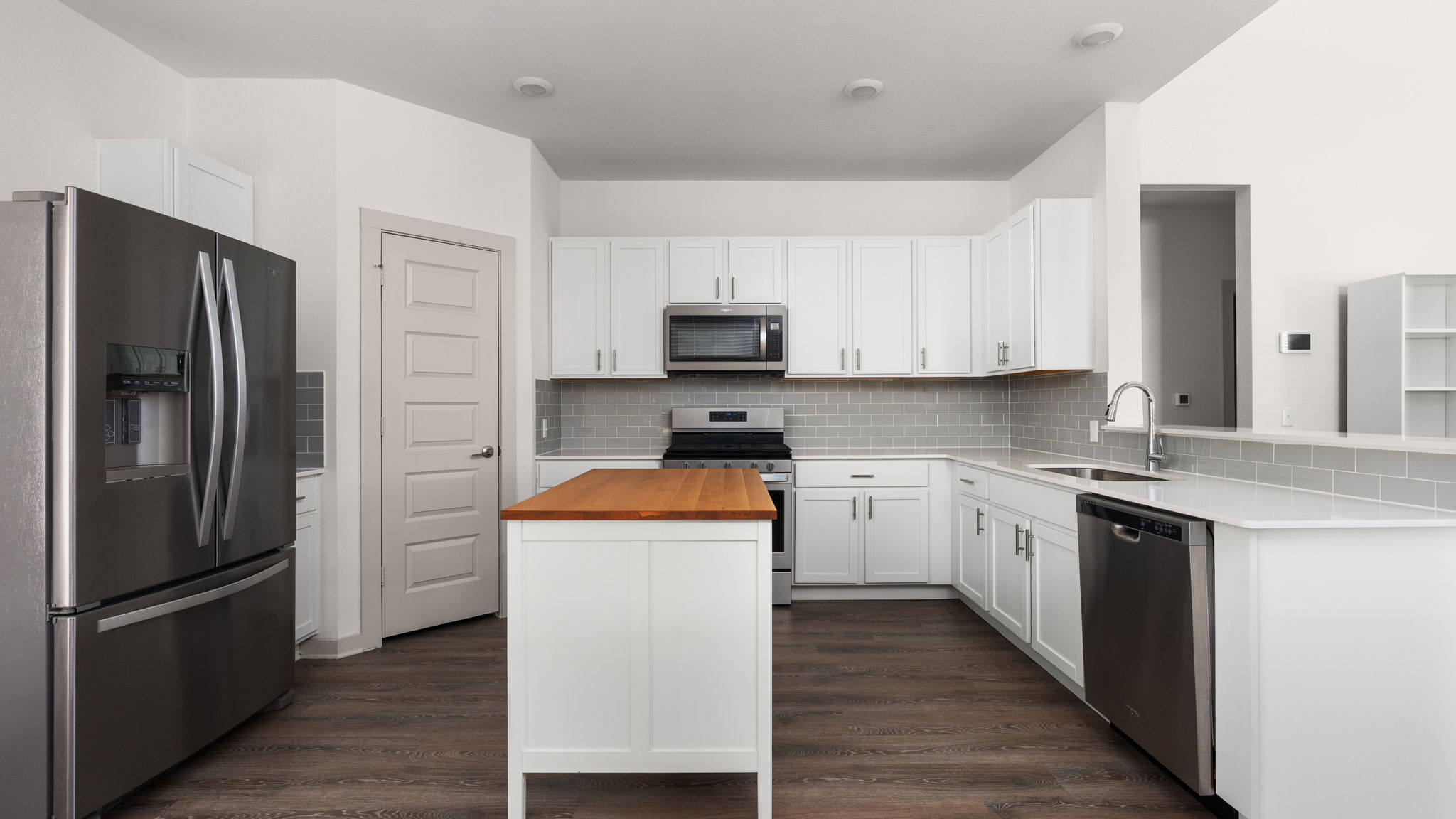 101 Merrick Road Georgetown, TX 78628 - Photo 9 of 38 Kitchen featuring stainless steel appliances, butcher block counters, white cabinetry, and dark wood-style flooring