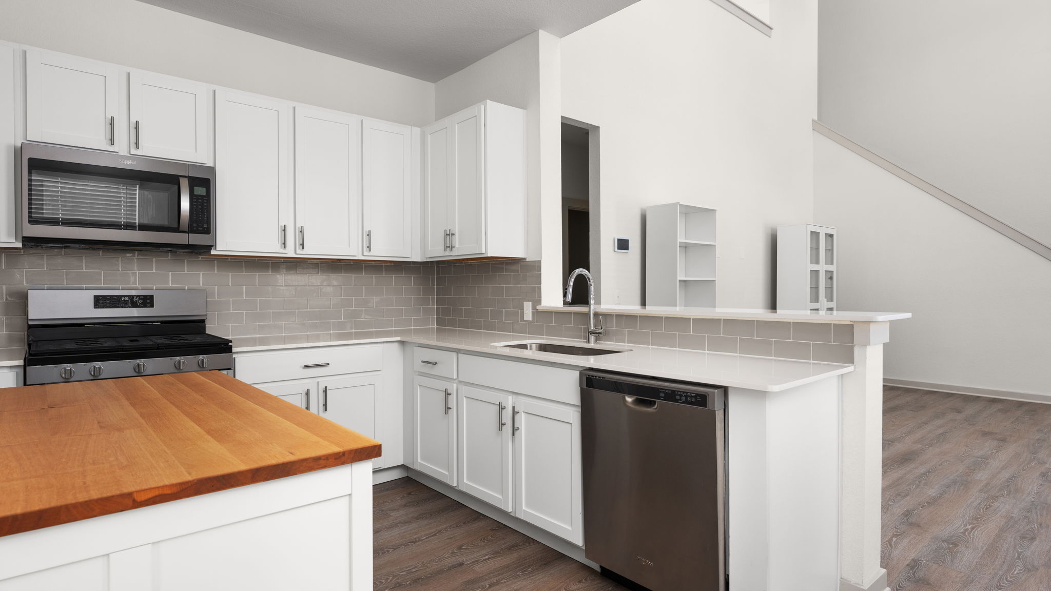 101 Merrick Road Georgetown, TX 78628 - Photo 10 of 38 Kitchen with butcher block counters, stainless steel appliances, white cabinets, and wood finished floors