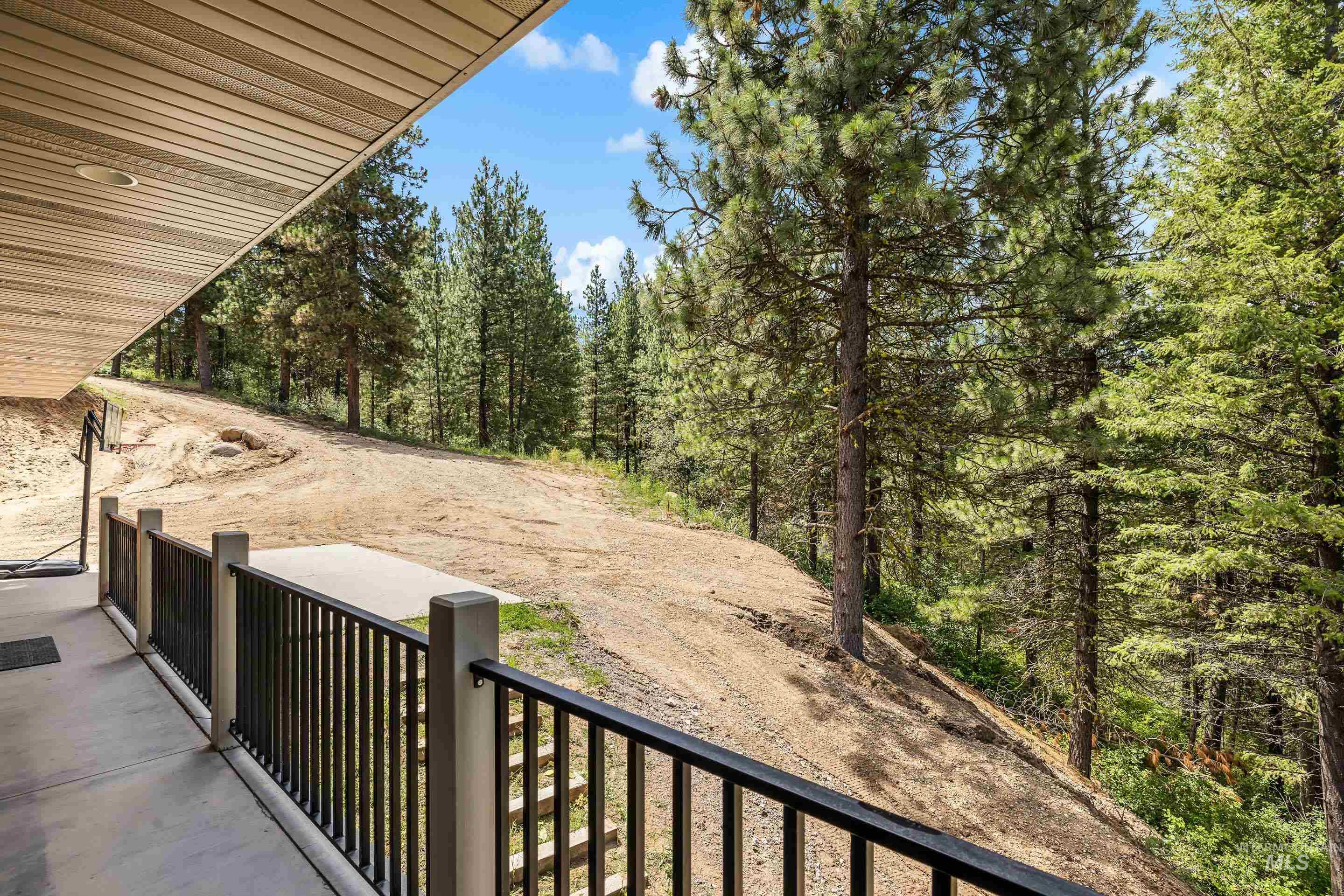 92 Cruickshank Road Horseshoe Bend, ID 83629 - Photo 50 of 50 Outdoor patio featuring a concrete surface, black metal railing, and wood-finish soffit