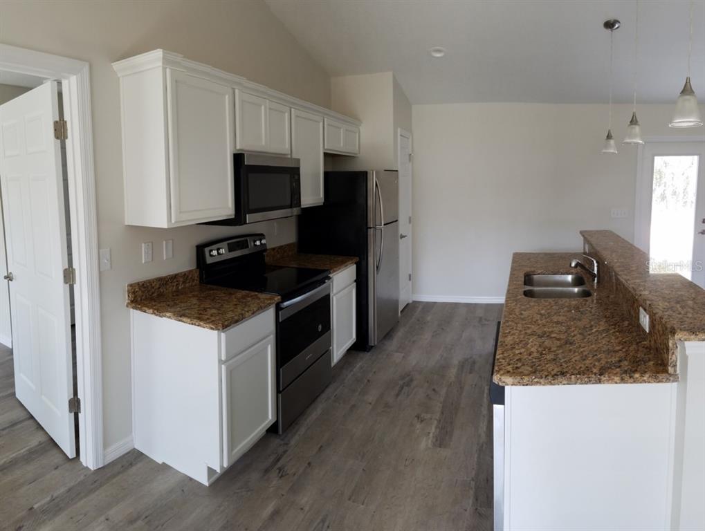 9 Fir Trail Ocala, FL 34472 - Photo 5 of 11 a kitchen with granite countertop a sink stove and refrigerator