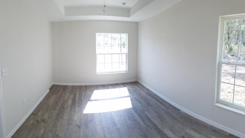 9 Fir Trail Ocala, FL 34472 - Photo 6 of 11 an empty room with wooden floor and windows