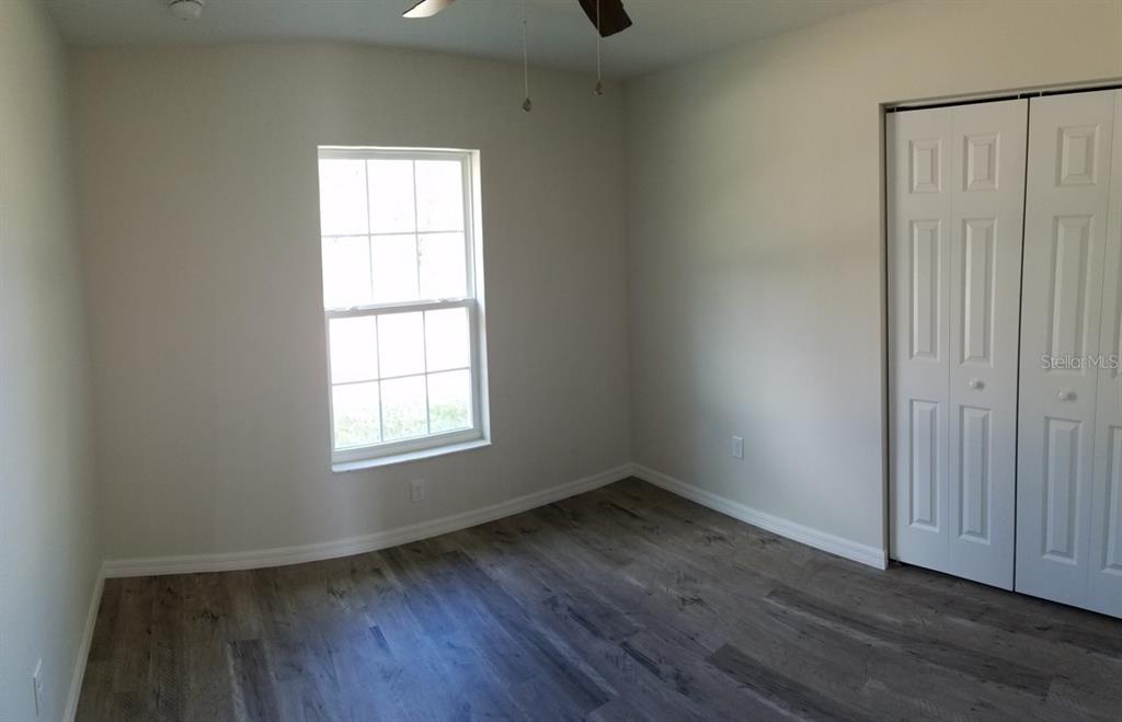 9 Fir Trail Ocala, FL 34472 - Photo 10 of 11 an empty room with wooden floor and windows