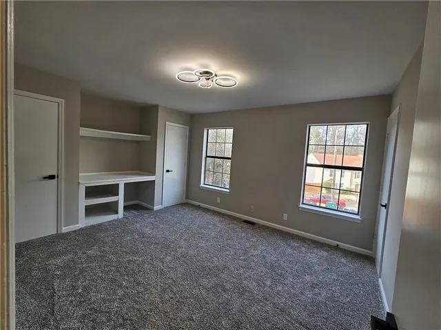an empty room with windows and closet