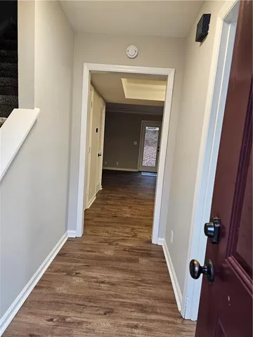 a view of a hallway with wooden floor and staircase