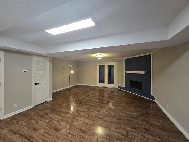 a view of an empty room with fire place and a window