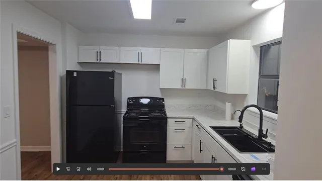a kitchen with a refrigerator and a stove top oven