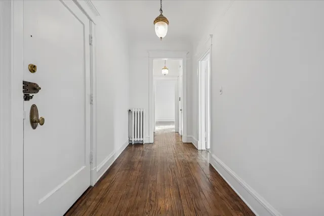 a view of a hallway with wooden floor