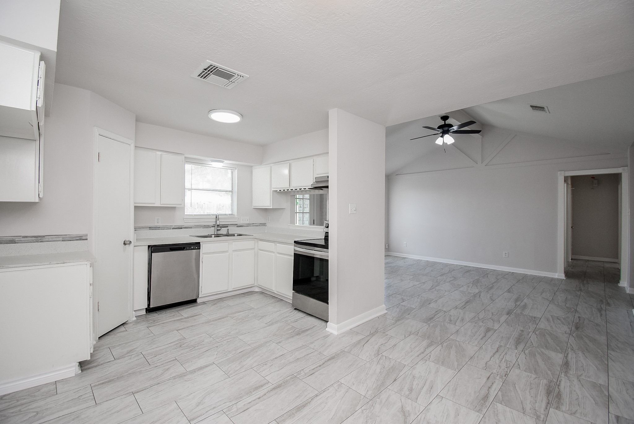 9527 Kingsvalley Drive Houston, TX 77075 - Photo 17 of 45 a kitchen with a refrigerator and white cabinets