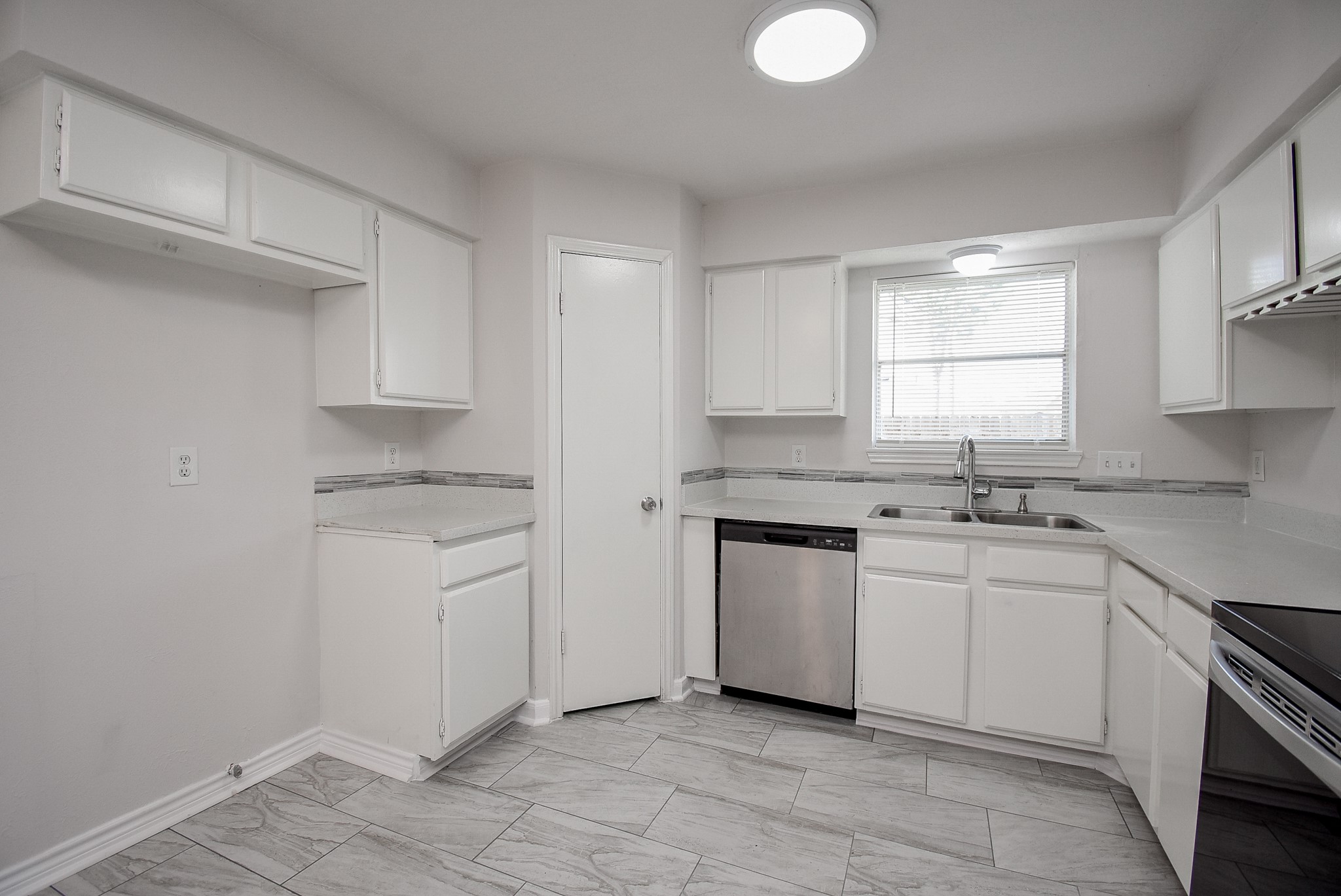 9527 Kingsvalley Drive Houston, TX 77075 - Photo 18 of 45 a kitchen with white cabinets appliances a sink and a window