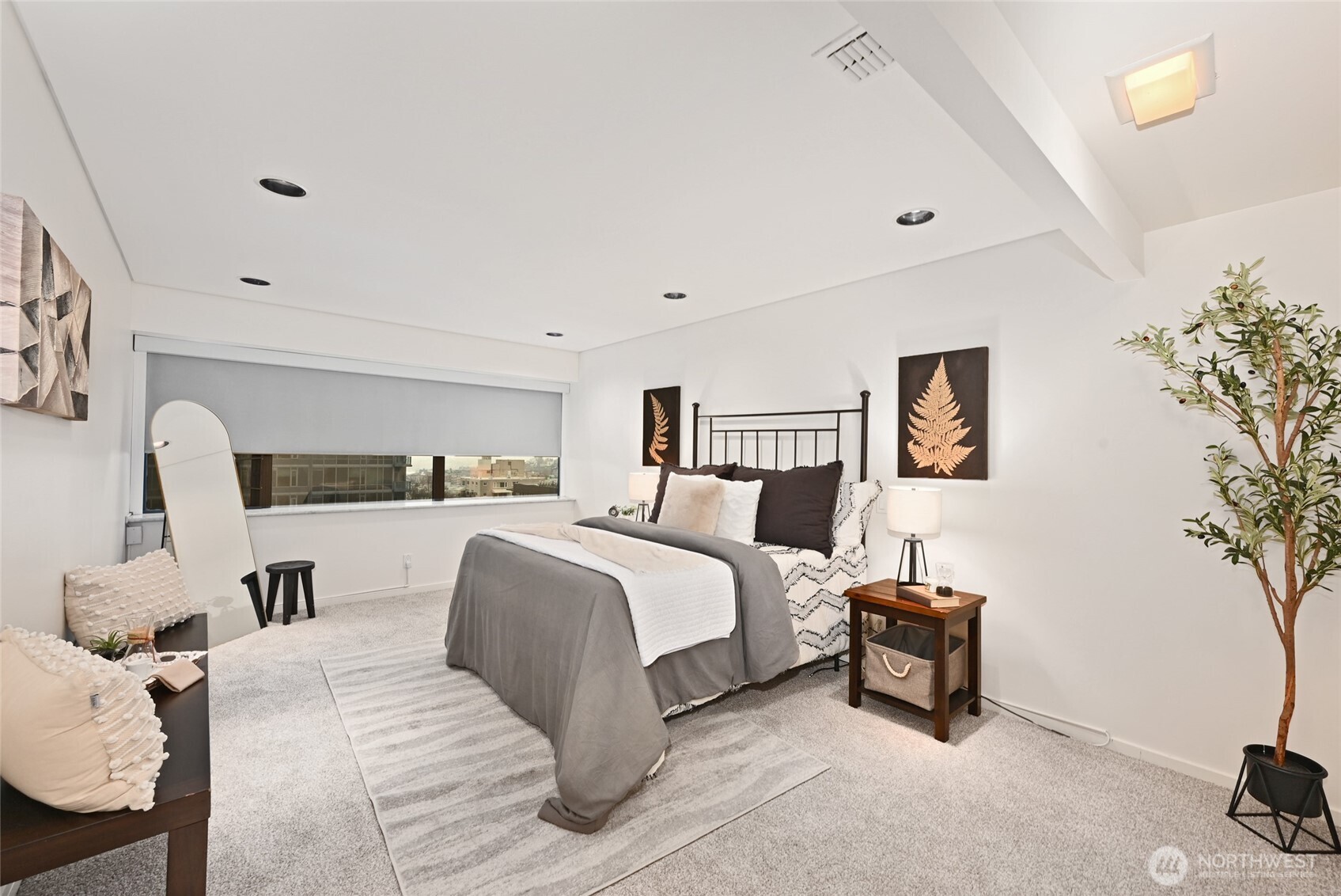 1301 Spring Street, Unit 10F Seattle, WA 98104 - Photo 18 of 36 a spacious bedroom with a bed and a couch