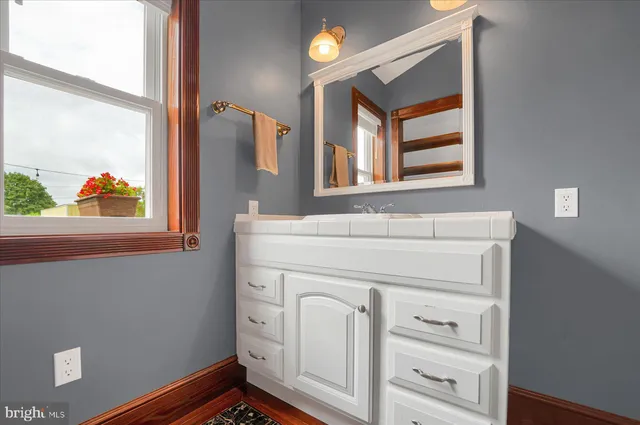 a bathroom with a sink a mirror and a window