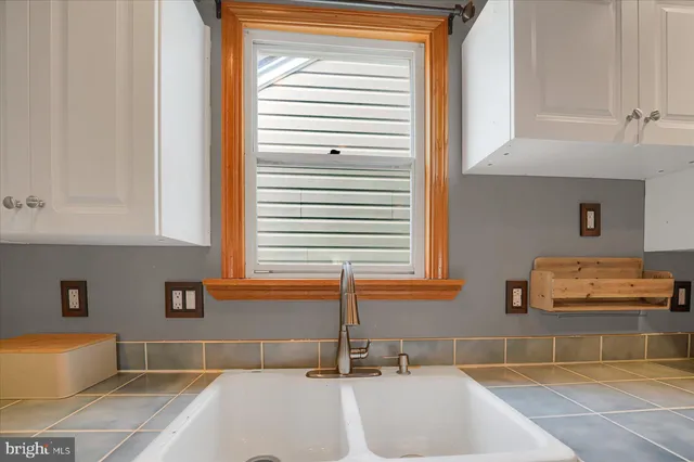 a bathroom with a tub a potted plant and a window