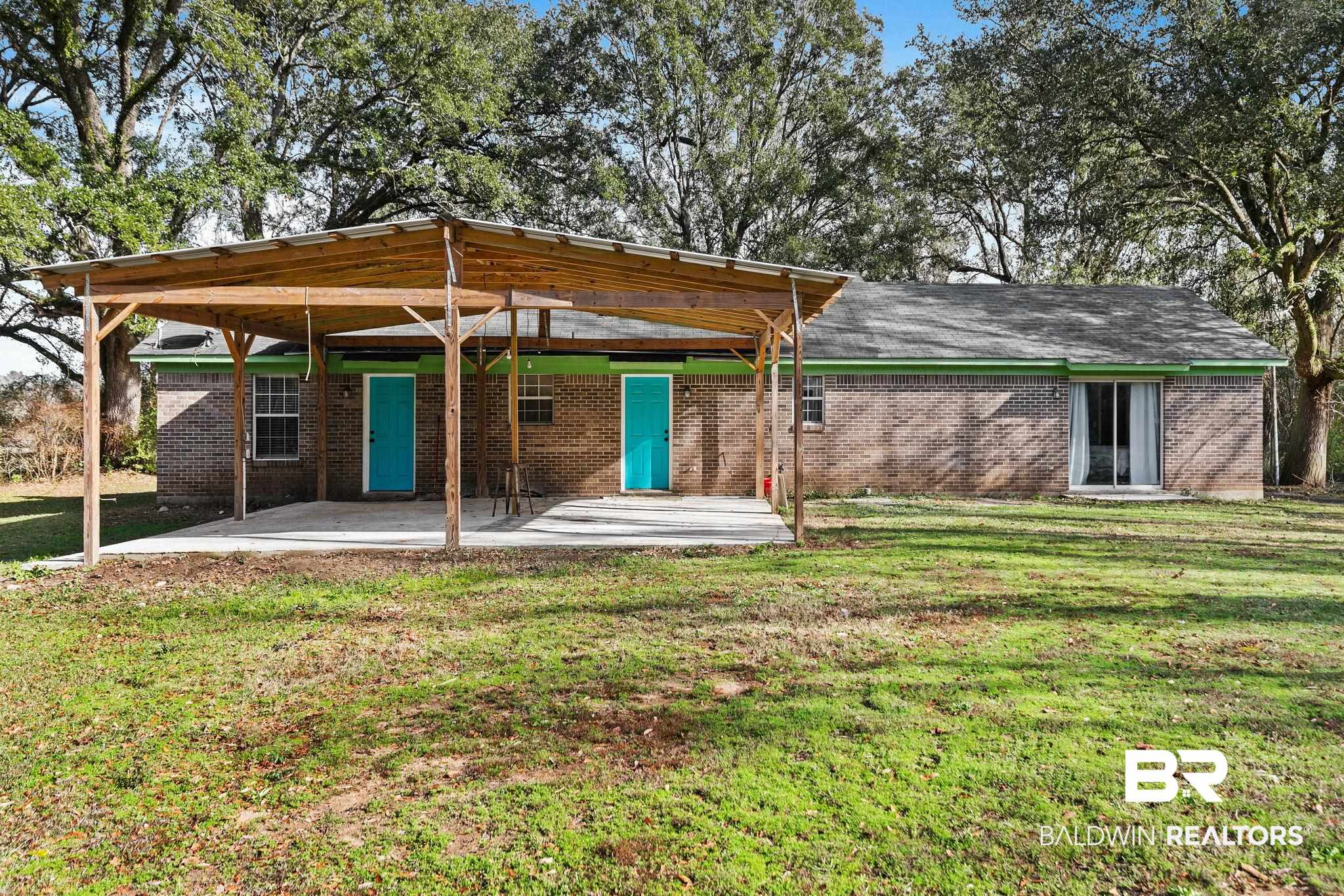 17366 Old Brady Road Bay Minette, AL 36507 - Photo 30 of 43 Rear view of property featuring brick siding, a patio, a yard, and a detached carport