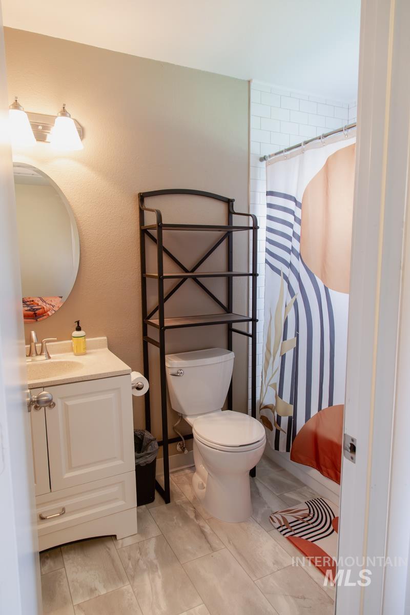 1404 Rochester Street Caldwell, ID 83605 - Photo 13 of 29 Bathroom featuring a white vanity with a light-colored countertop and an oval mirror