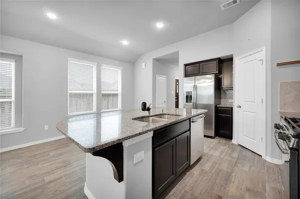 a kitchen with stainless steel appliances granite countertop a sink stove and refrigerator