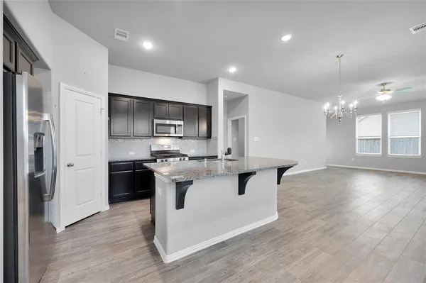 a kitchen with kitchen island a sink stainless steel appliances and cabinets