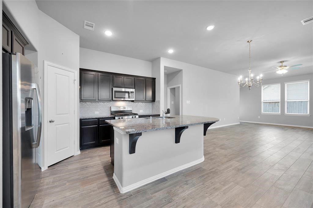 3137 Dunsmore Manor Court Spring, TX 77386 - Photo 14 of 32 a kitchen with kitchen island a sink stainless steel appliances and cabinets