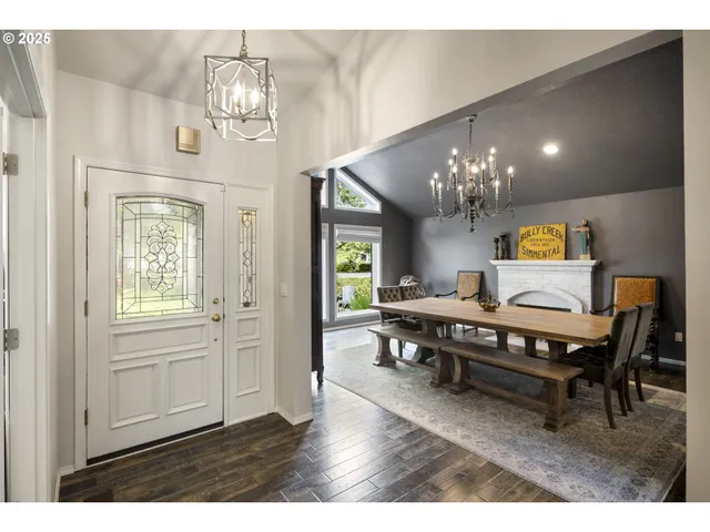 a view of a dining room with furniture a chandelier and wooden floor