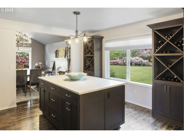 a kitchen with stainless steel appliances granite countertop a dining table chairs and chandelier