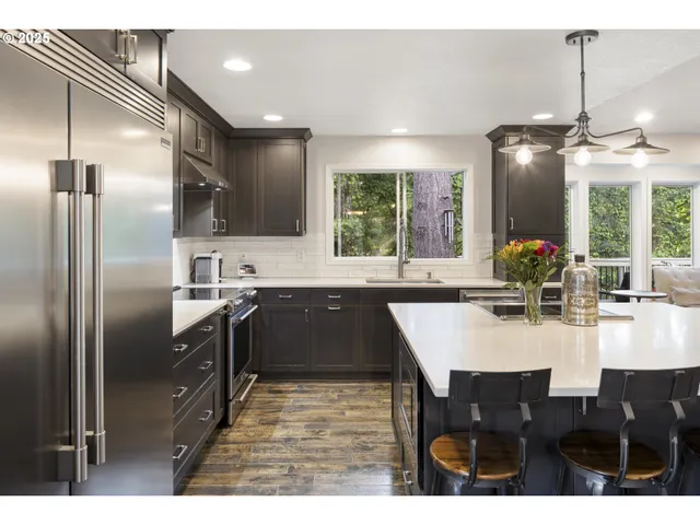 a kitchen with kitchen island granite countertop a sink stainless steel appliances and cabinets