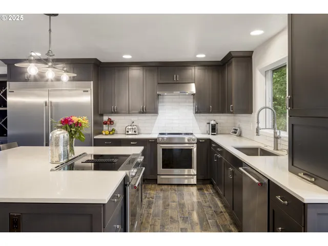 a kitchen with kitchen island a counter top space cabinets and stainless steel appliances