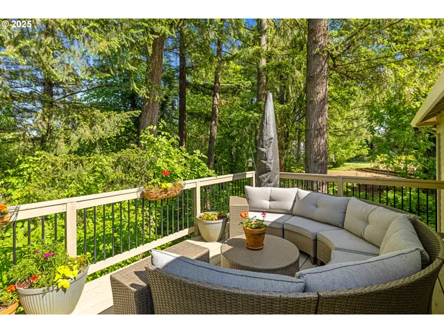 a balcony with wooden floor table and chairs