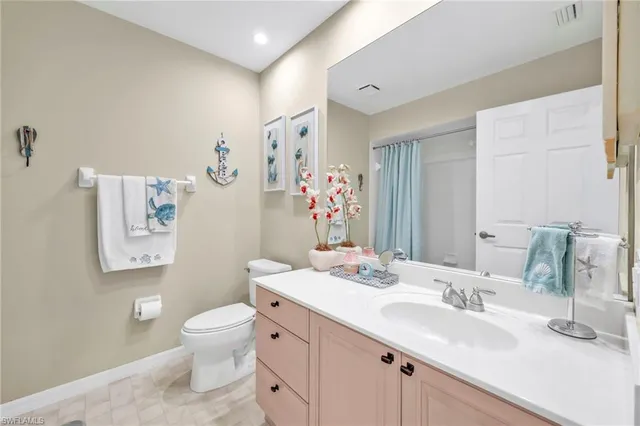 a bathroom with a sink vanity mirror and toilet