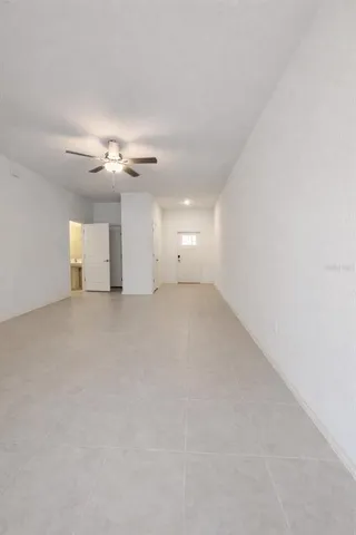 a view of an empty room with a chandelier fan