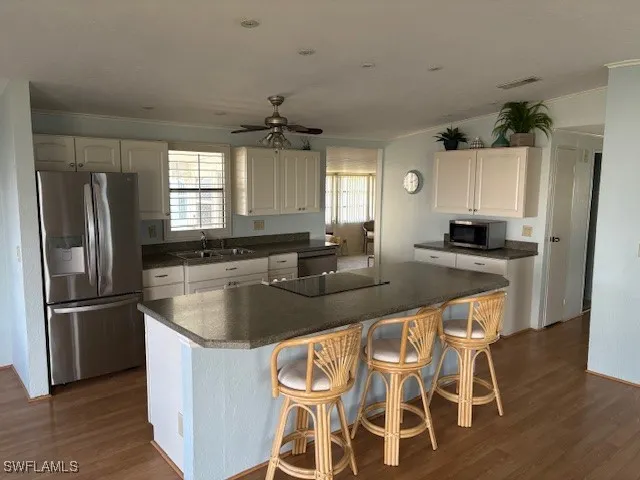 a kitchen with kitchen island granite countertop a sink and refrigerator
