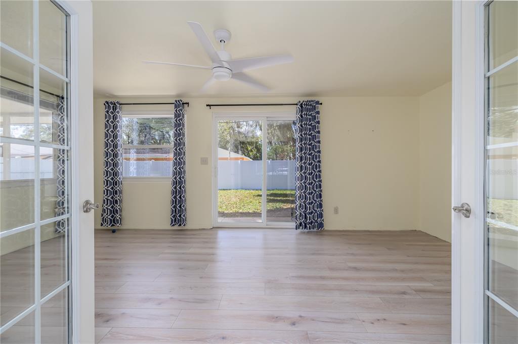 1016 Cherokee Ranch Road Holly Hill, FL 32117 - Photo 7 of 23 an empty room with wooden floor and windows