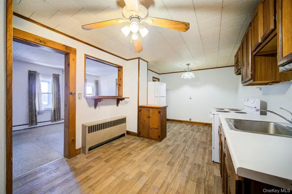 a view of a livingroom with wooden floor and a ceiling fan