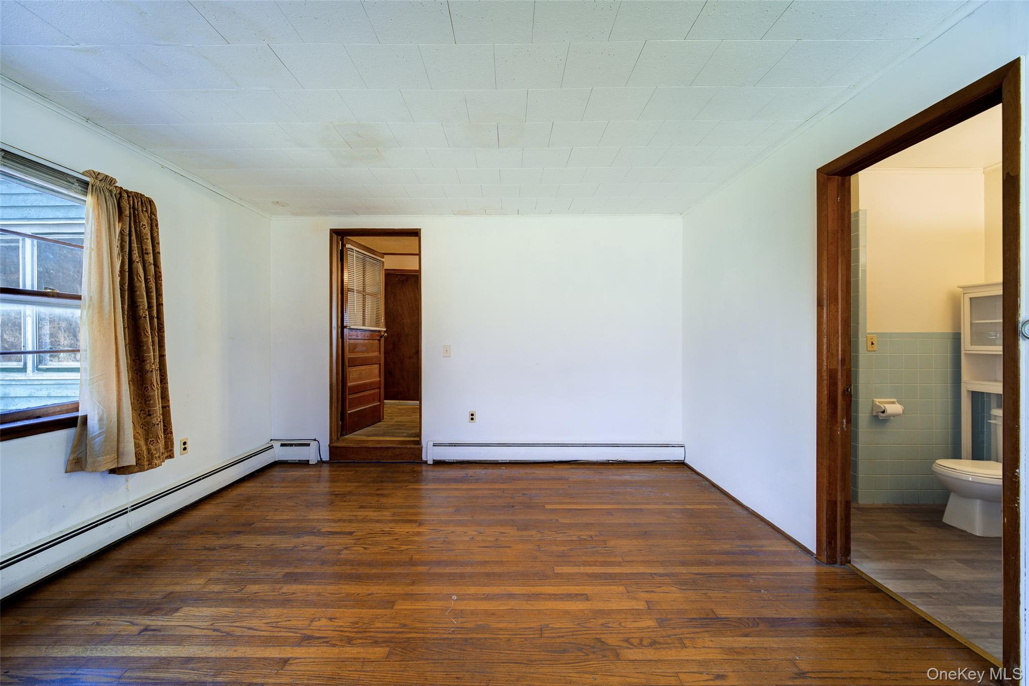 166 Brookside Farms Road Newburgh, NY 12550 - Photo 14 of 45 a view of an empty room and bathroom with wooden floor and a window
