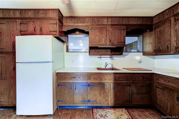 a view of a kitchen with a sink stove cabinets and empty room