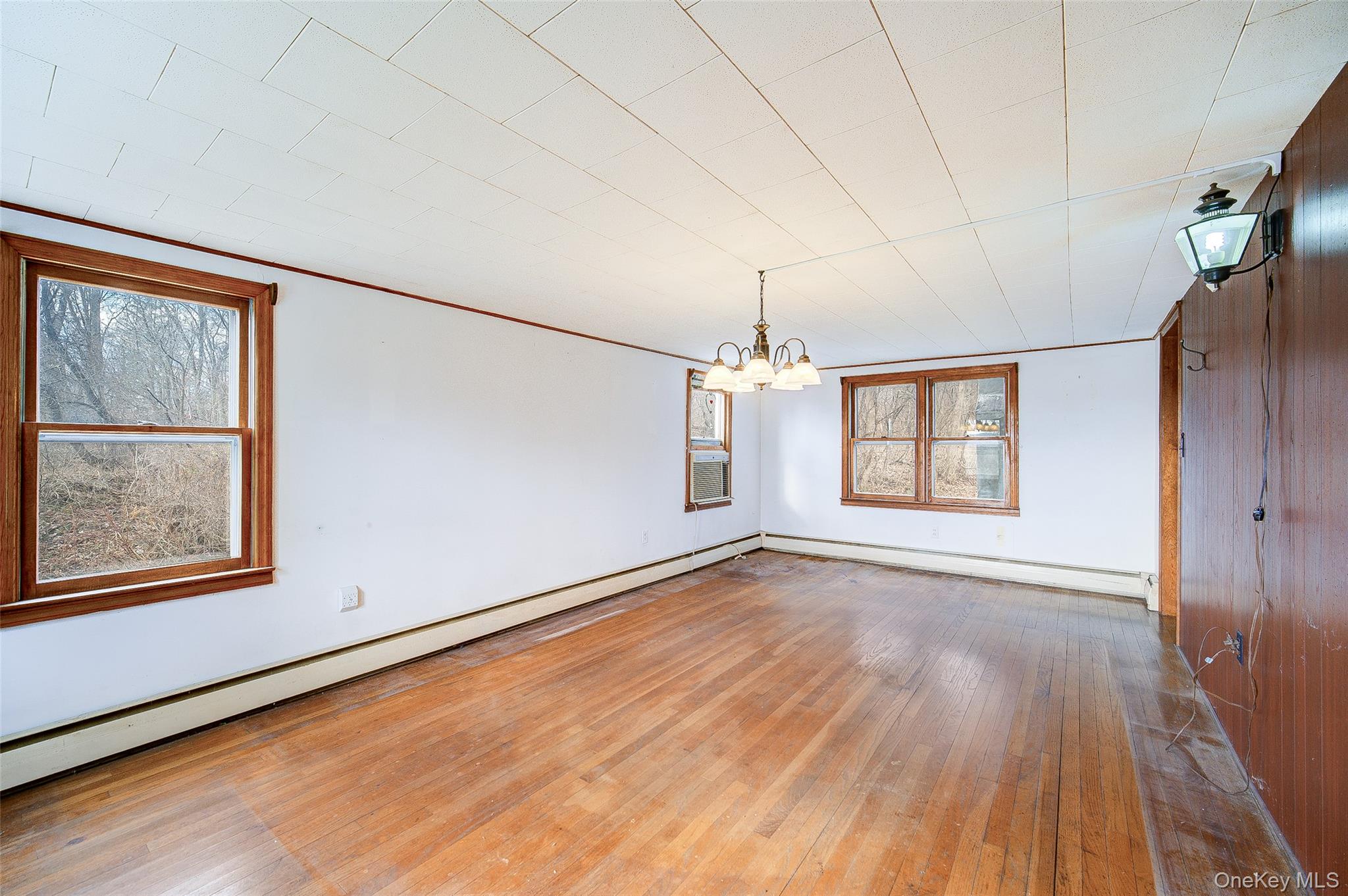 166 Brookside Farms Road Newburgh, NY 12550 - Photo 26 of 45 an empty room with wooden floor chandelier and windows