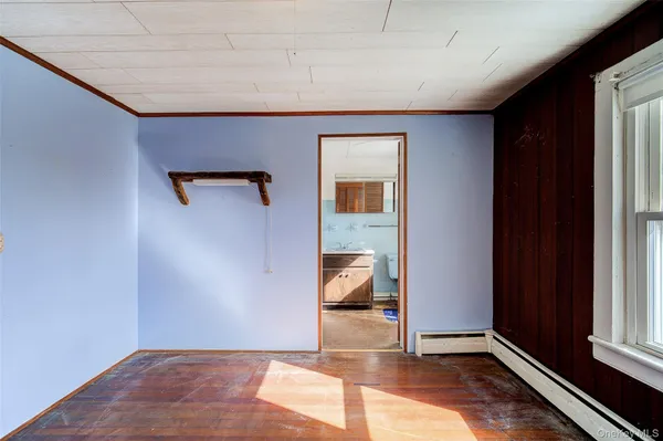 an empty room with wooden floor a ceiling fan and windows