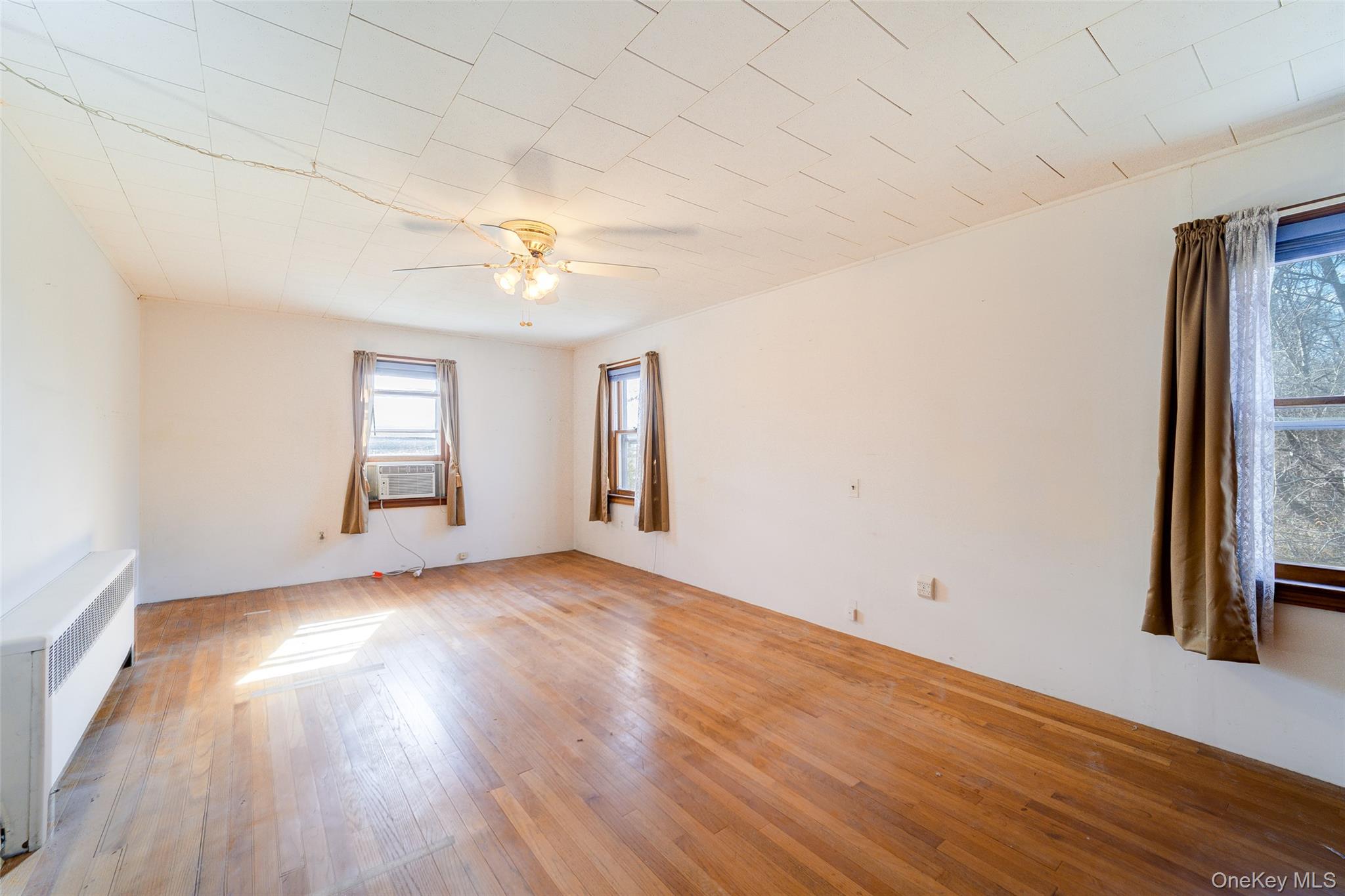 166 Brookside Farms Road Newburgh, NY 12550 - Photo 29 of 45 an empty room with wooden floor a ceiling fan and windows