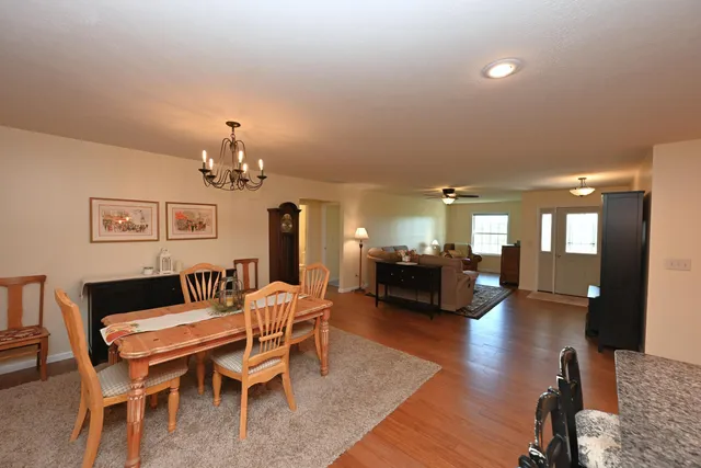 a dining room with furniture a chandelier and wooden floor