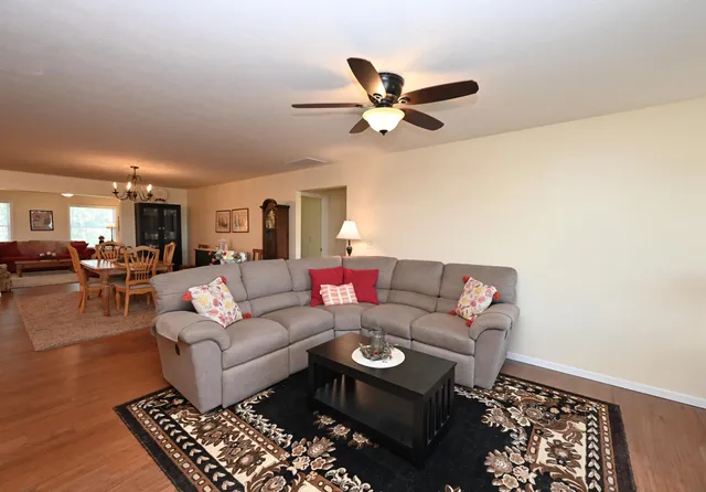 a living room with furniture and a view of kitchen