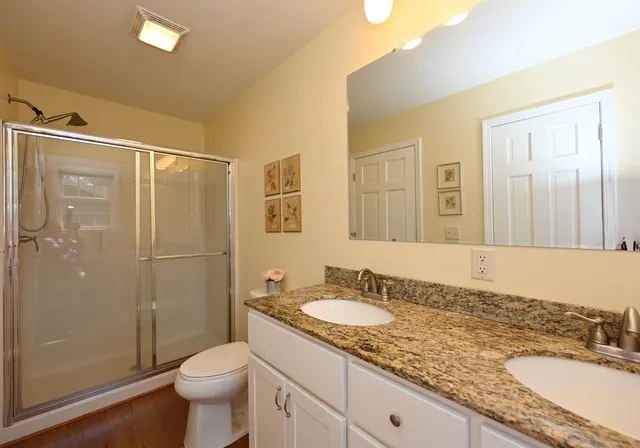 a bathroom with a granite countertop sink toilet and shower