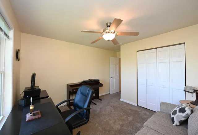 a view of workspace with wooden floor and ceiling fan