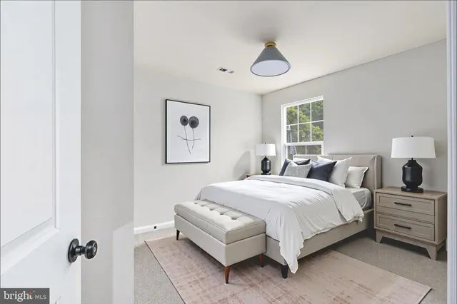 a view of an empty room with a window and a kitchen