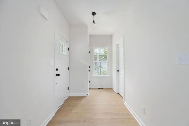 a kitchen with a sink and white cabinets with stainless steel appliances